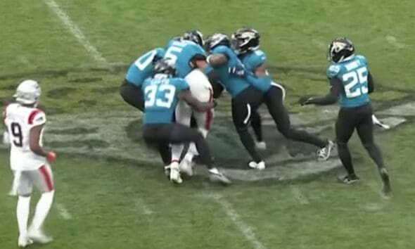 New England Patriots tight end Hunter Henry gets tackled by a group of Jacksonville Jaguars players in their Week 7 game.